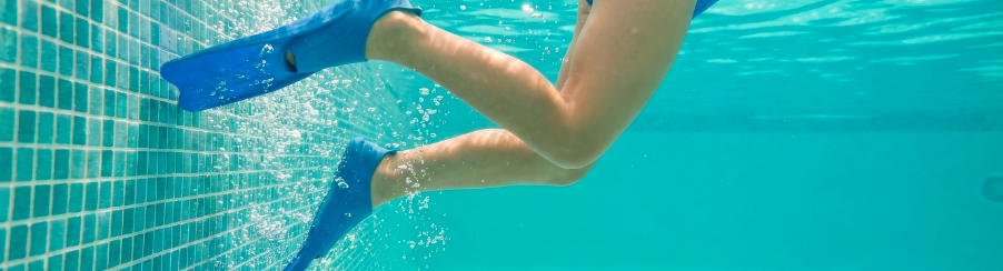 Kinder mit Schwimmflossen beim Training im Schwimmbad