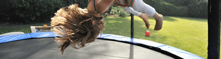 Kinder spielen und hüpfen auf einem sicheren Kindertrampolin im Garten