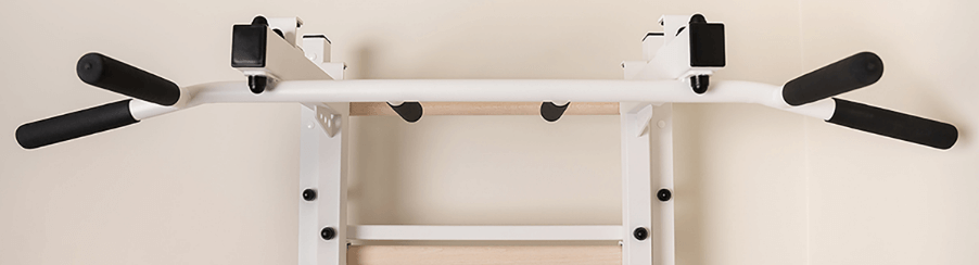 Fitnessbegeisterte nutzen eine Klimmzugstange an der Sprossenwand für vielseitiges Heimtraining und effektive Klimmzugübungen