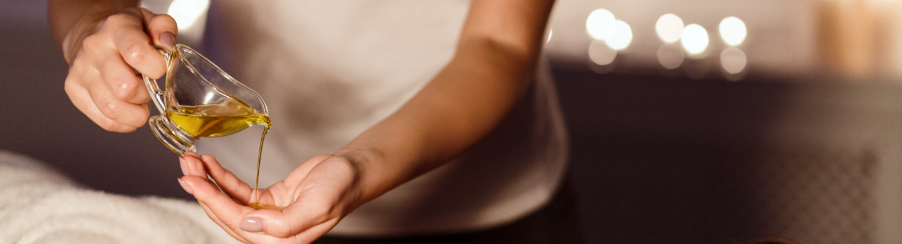 Therapeuten tragen Massageöl für Physiotherapie auf die Haut eines Patienten während einer Behandlung auf