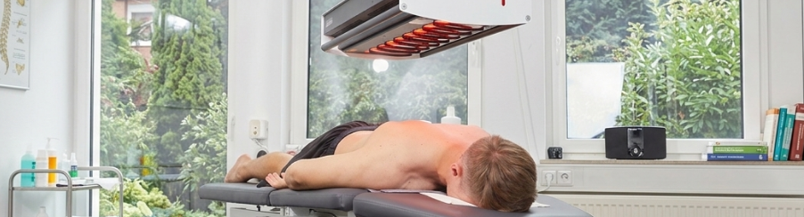 Physiotherapeut verwendet ein physikalisches Therapiegerät bei der Behandlung in einer modernen Praxisumgebung