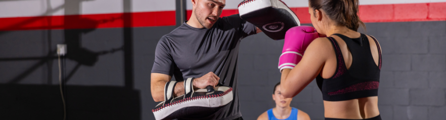 Trainingspartner hält ein Schlagpolster im Training zur Aufnahme von Schlägen und Kicks fest