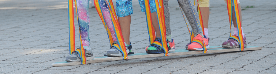 Mehrere Personen beim Sommerskifahren auf Sommerski mit Fußschlaufen bei einem Freizeitspiel im Sommer