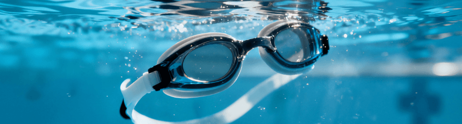 Wassersportler trägt eine Taucherbrille und blickt durch das klare Wasser