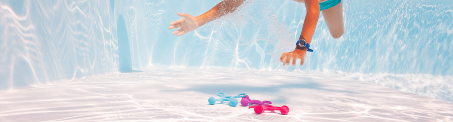 Verschiedene Tauchspielzeuge im Einsatz am Beckenrand für Wassersport und Schwimmtraining