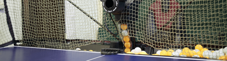 Vielfältiges Tischtennis Zubehör für Racketsportler, wie Schläger, Bälle und Netze, auf einer Tischtennisplatte im Einsatz