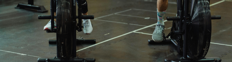 Zwei Personen auf einem Crosstrainer im Fitnessstudio