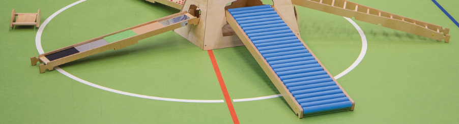 Rollenrutsche in Bewegungslandschaft integriert und am Trapezturnkasten eingehängt